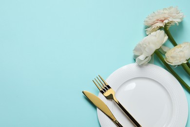 Photo of Stylish table setting with cutlery and flowers on light blue background, flat lay. Space for text