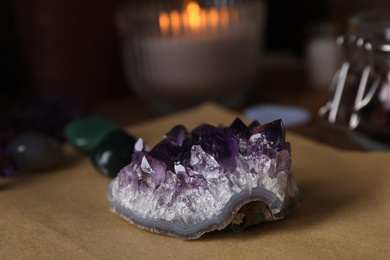 Composition with healing amethyst gemstone on table, closeup