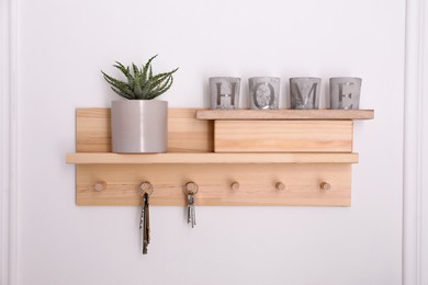 Wooden hanger for keys with decor on white wall