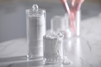 Cotton buds and pads in transparent holders on light table