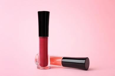 Beautiful lip glosses on color background