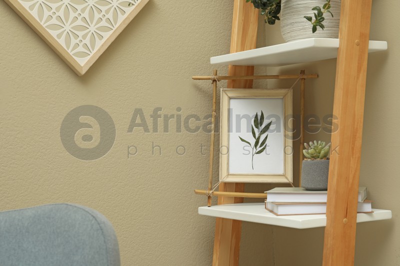 Bamboo frame and different decor elements on shelving unit indoors