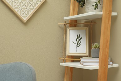 Bamboo frame and different decor elements on shelving unit indoors