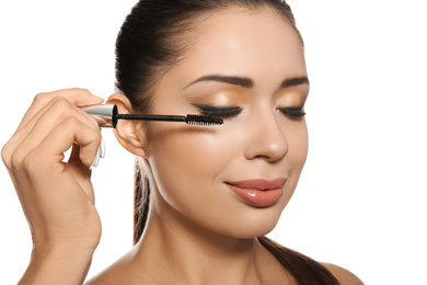 Beautiful woman applying mascara on white background. Stylish makeup