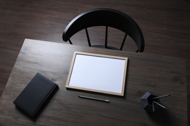 Modern wooden table with stationery and chair indoors