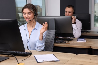 Call center operators with headsets working in modern office