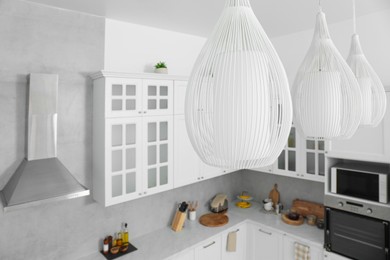 Photo of Stylish chandeliers in modern kitchen. Interior design