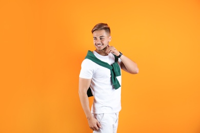 Young man with trendy hairstyle on color background