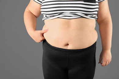 Overweight woman on gray background, closeup view