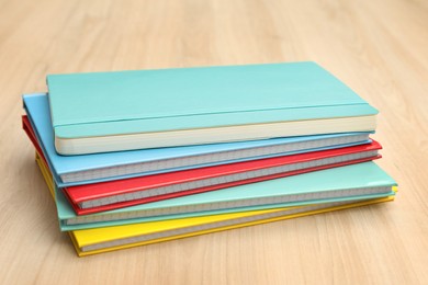 Stack of colorful planners on wooden table