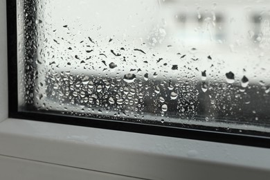 Window glass with drops of condensate indoors, closeup
