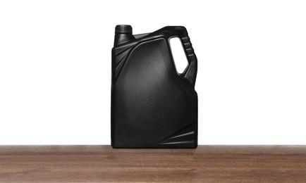 Motor oil in black container on wooden table against white background