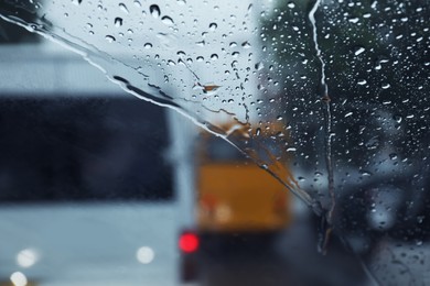 Photo of Blurred view of road through wet car windscreen. Rainy weather