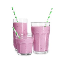 Glasses of blackberry smoothie with straws on white background