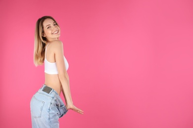Slim woman in oversized jeans on color background, space for text. Perfect body