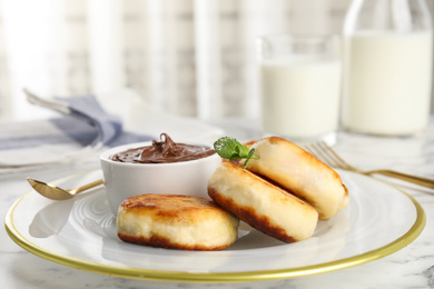 Delicious cottage cheese pancakes with chocolate paste on plate, closeup