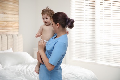 Female orthopedist with cute little baby indoors
