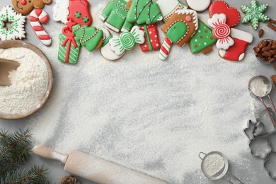 Delicious homemade Christmas cookies and flour on grey table, flat lay. Space for text