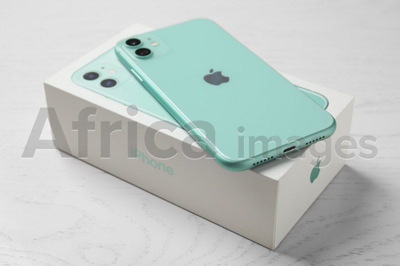 Photo of MYKOLAIV, UKRAINE - JULY 10, 2020: New modern Iphone 11 Green and original box on white wooden table