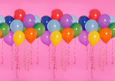 Many color balloons on pink background. Festive decor