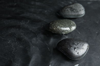 Stones in water on dark background, space for text. Zen lifestyle