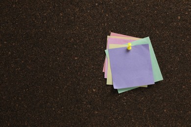 Colorful paper notes pinned to cork board. Space for text