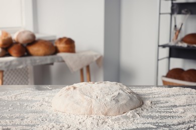 Photo of Fresh dough with flour on table in kitchen
