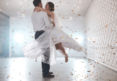 Photo of Happy newlywed couple dancing together in festive hall