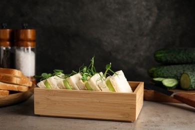 Photo of Tasty sandwiches with cucumber and microgreens on grey table