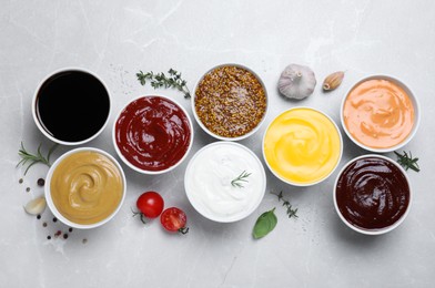 Many different sauces on light grey table, flat lay