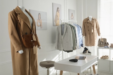 Collection of stylish women's clothes, shoes and accessories in modern boutique