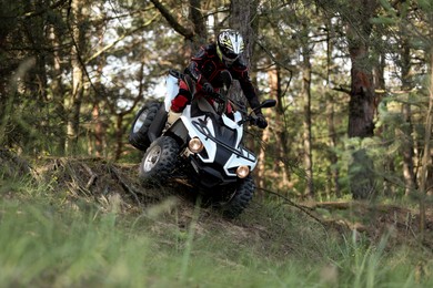 Man driving modern quad bike in forest. Extreme sport