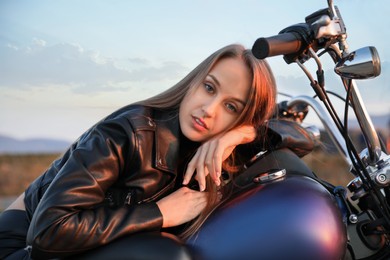 Photo of Beautiful young woman on motorcycle outdoors in evening