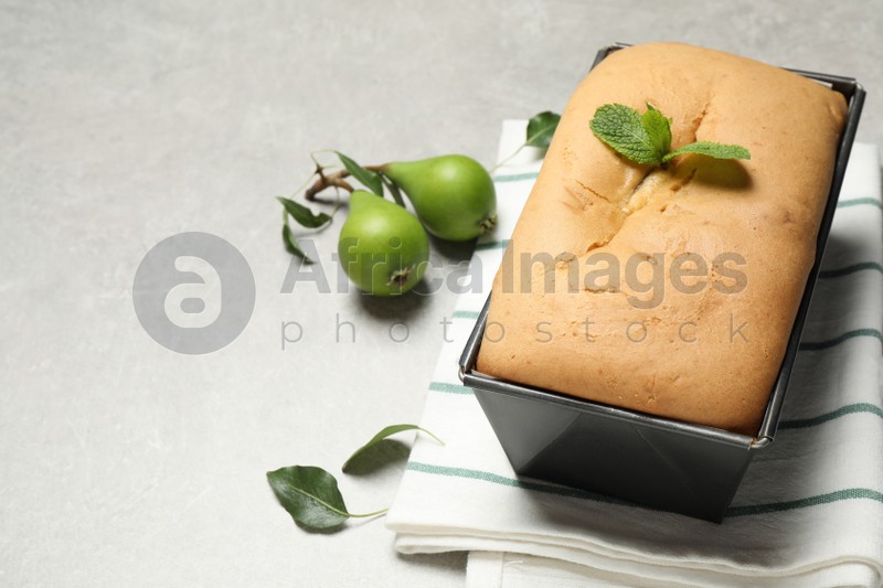 Photo of Tasty bread with mint and pears on light grey table. Homemade cake