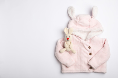 Child's clothes and toy bunny on white background, top view