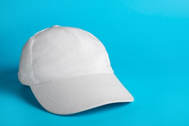 Baseball cap on light blue background, space for text