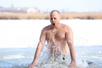 MYKOLAIV, UKRAINE - JANUARY 19, 2021: Man immersing in icy water on winter day. Traditional Baptism ritual