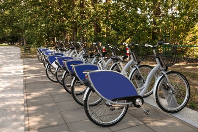 Parking rack with many bicycles outdoors. Bike rental
