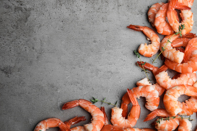 Photo of Tasty boiled shrimps with thyme on grey table, flat lay. Space for text