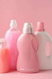 Photo of Bottles of laundry detergents on pink background