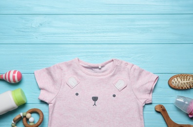 Photo of Baby clothes and accessories on light blue wooden background, flat lay. Space for text