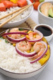 Photo of Delicious poke bowl with shrimps, rice and vegetables on white table, closeup