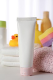 Photo of Tube of baby care product and towels on white table indoors
