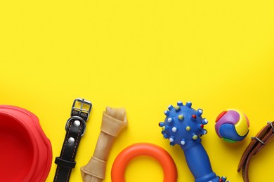 Flat lay composition with dog collars and different accessories on yellow background, space for text