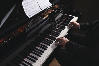 Man playing grand piano, closeup. Talented musician
