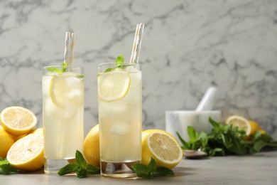 Photo of Natural lemonade with mint and fresh fruits on light grey table, space for text. Summer refreshing drink