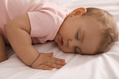 Photo of Adorable little baby sleeping on bed, closeup