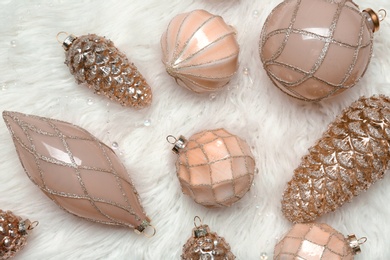 Collection of beautiful Christmas tree baubles on white faux fur, flat lay