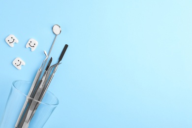 Flat lay composition with dentist tools and decorative teeth on color background. Space for text