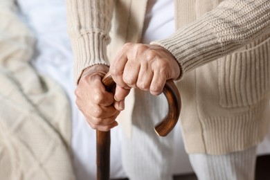 Elderly woman with walking cane indoors, closeup. Home care service